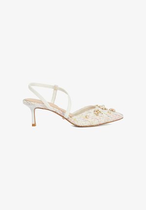 Sandale slingback tissée blanche avec bout pointu, tissu texturé, talon bas et ornements décoratifs comprenant des perles et des accents floraux.