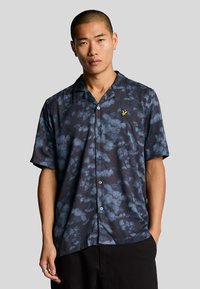 Camicia a maniche corte con un motivo a nuvola blu scuro, dotata di chiusura a bottoni e un piccolo logo giallo sul petto.