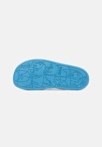 Suela de goma azul con dibujos lineales únicos, texto y una superficie suave. Nombre de la marca "Camper" grabado cerca del talón.