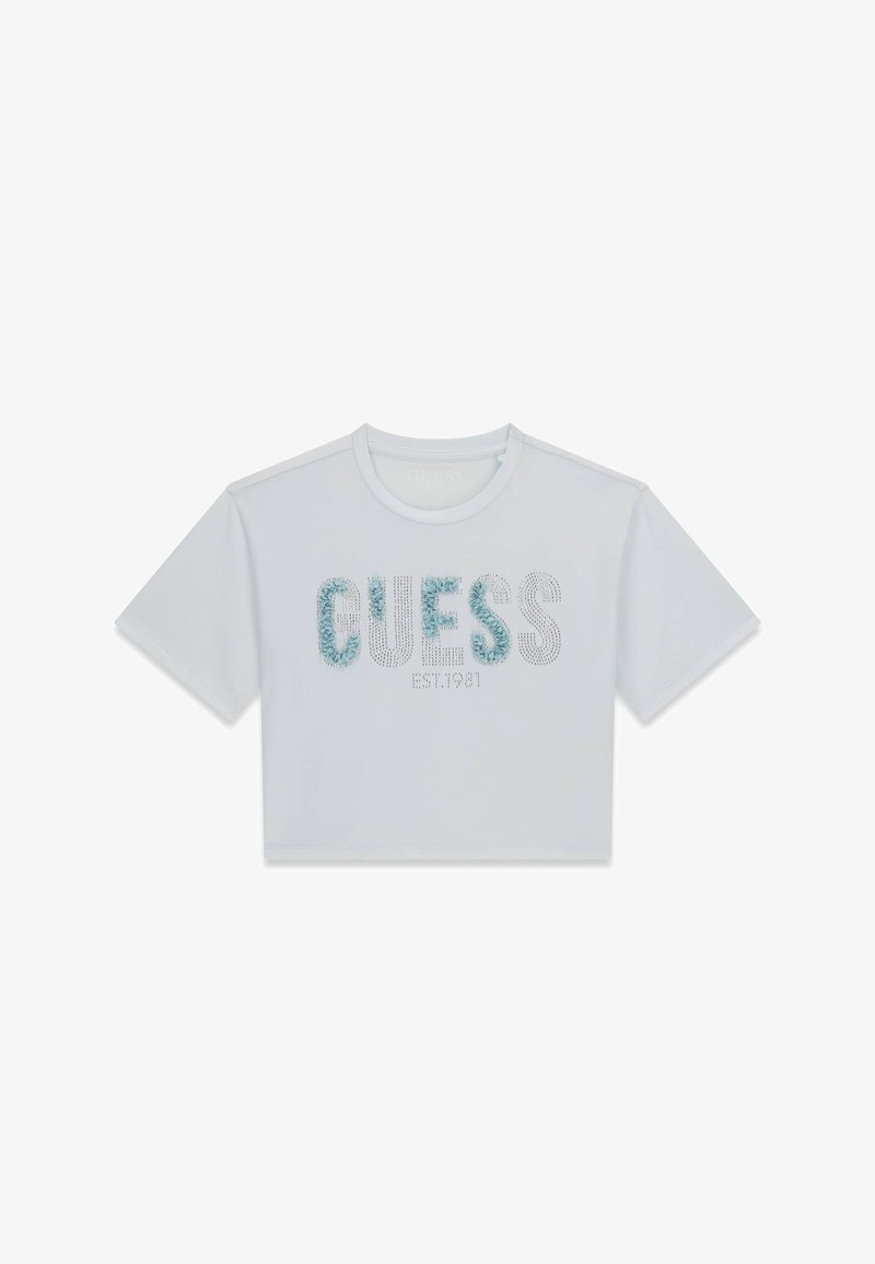 T-shirt blanc court à manches courtes avec l'inscription "GUESS EST.1981" en grandes lettres texturées sur le devant.