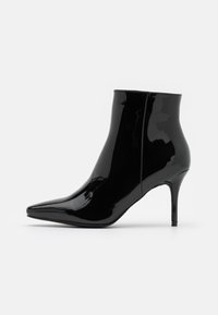 Bottines en cuir verni noir avec un bout pointu et un talon aiguilles fin. Finition lisse et brillante avec un design minimaliste.