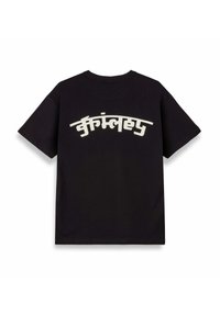 Camiseta de algodón negra con mangas cortas y un gráfico de texto en blanco curvado en la parte posterior, que presenta un diseño moderno y audaz.