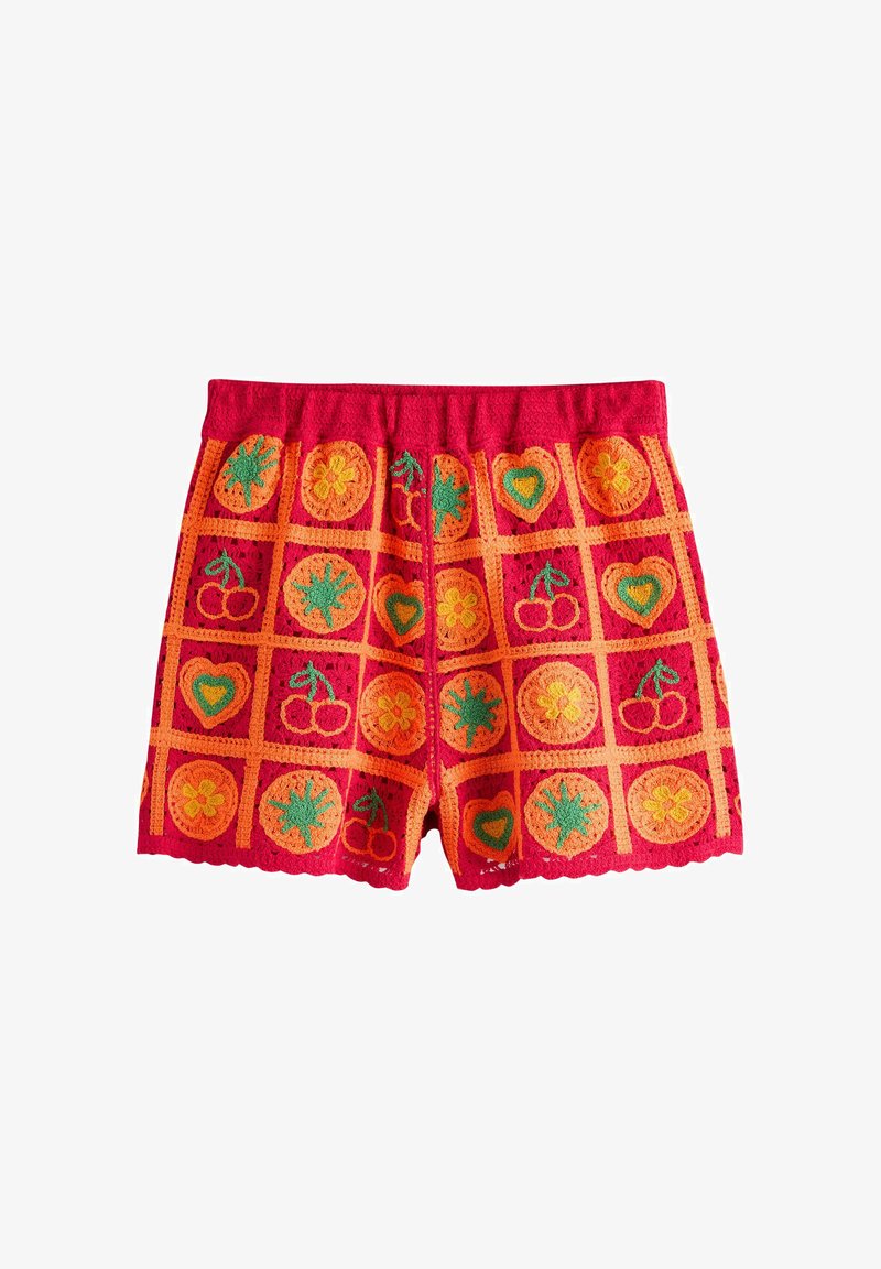 Shorts rouges en crochet avec un motif à grille orange présentant des cœurs verts et jaunes, des cerises, des fleurs et des motifs d'explosion d'étoiles.