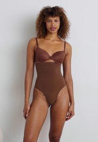 Brauner Bodysuit mit tiefem Ausschnitt, der verstellbare Träger und eine glatte Textur aufweist. Entworfen mit einem hohen Beinausschnitt und minimalistischen Stil.