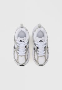 Białe sneakersy z siateczki z srebrnymi akcentami, z miękką podeszwą, okrągłym noskiem, sznurowanym zapięciem i pętelką na pięcie.