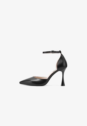 Décolleté con tacco alto in pelle nera con punta affilata, cinturino alla caviglia e un design unico del tacco svasato. Texture liscia e dettagli hardware minimi.