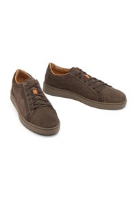 Bruine suède sneakers met veters, rubberen zool en contrasterende oranje en blauwe accenten nabij de tong. Zachte voering aan de binnenkant.