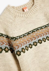 Stickad krämfärgad tröja med ett mönstrat band i grönt, persika och ljusblått. Rund halsringning och texturerade detaljer förbättrar designen.