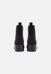 Mustad musta nahast ankle boots külgmiste tõmblukkudega, tekstureeritud ülaosa süvistatud nukkide ja tugeva puidust kergelt kitseneva kontsaga.