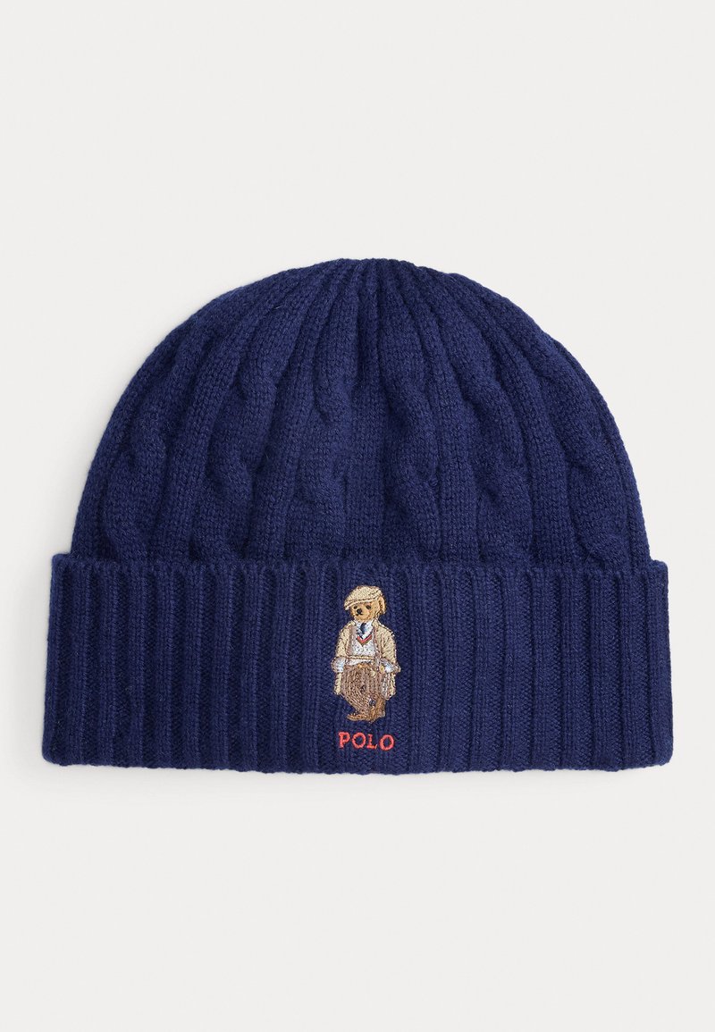 Gorro de malha azul-marinho com textura canelada e design em ponto pipoca. Apresenta um urso bordado de fato e o texto "POLO" em vermelho.
