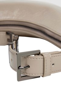 Krupan plan bežnog kožnog remena s srebrnim metalnim kopčanjem i finim detaljem šivanja.