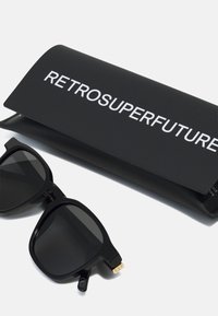 Occhiali da sole neri con lenti scure, design con montatura quadrata e dettagli dorati sulle tempie. Vengono forniti con un astuccio nero con il logo "RETROSUPERFUTURE".