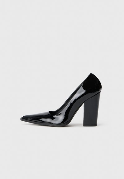 Black patent leather high heel shoe with a pointed toe and a chunky heel, featuring a smooth, glossy surface and a sleek design.