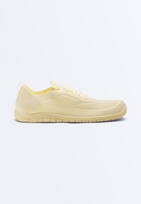 Light beige knitted fabric sneaker with lace-up front, flexible sole, and pull tab on the heel, shown in side profile on white background.