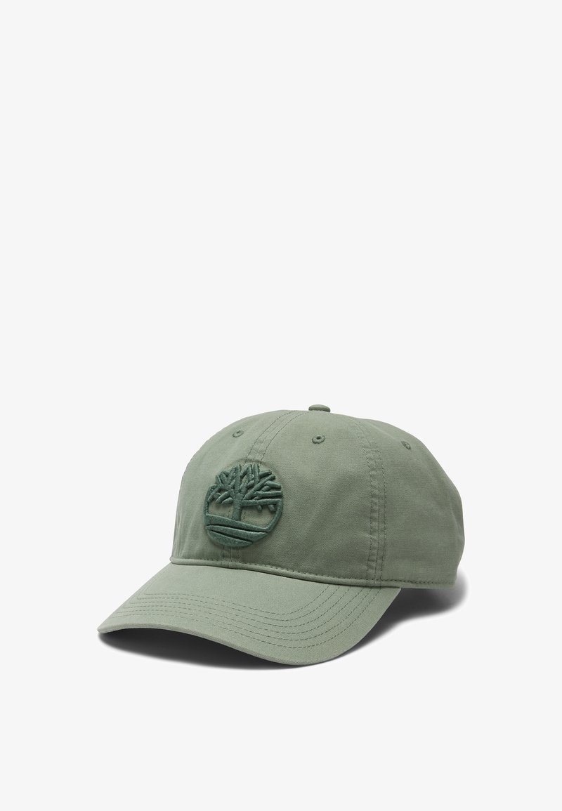 Grön bomullsmössa med en broderad trädlogotyp på framsidan, böjd skärm, sexpanelig design och ventilationshål.