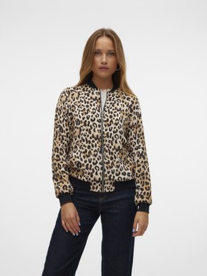 Leopardmønstret bomberjakke med lynlås foran, sorte ribbede mansjetter og kant, samt bløtt stoff. Modellen har den på over mørke jeans.