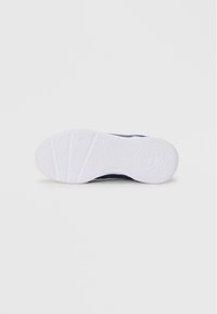 Blå tekstil-sneaker med en hvid gummisål med hexagonalt mønster og logo-detalje. Designet er sporty med teksturerede accenter.