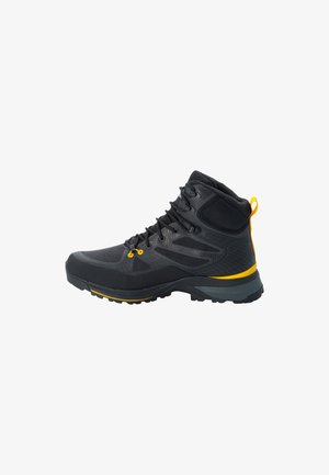 Botte de randonnée noire avec accents gris, panneaux en maille texturée, œillets jaunes et collier rembourré. Caractérisée par une semelle robuste pour une bonne traction.