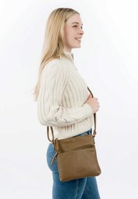 Borsa a tracolla in pelle marrone con due scomparti con cerniera, forma rettangolare, superficie strutturata e tracolla regolabile.