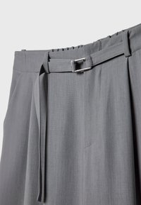 Pantalon gris taille haute avec ceinture en tissu et boucle rectangulaire argentée, doté d'une ceinture élastique et de passants de ceinture.