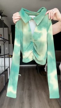 Grünes und gelbes Batik-Ripp-Shirt mit langen Ärmeln, abgerundetem Saum, Kragen und Raffung vorne.