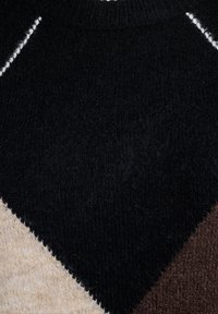 Sweter dzianinowy z wzorem w romby w kolorach czarnym, beżowym i ciemnobrązowym, z prążkowanym dekoltem i kontrastującymi detalami na szwach.