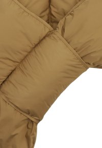 Detalles de una chaqueta de plumas marrón, con un diseño acolchado que presenta una textura suave y brillante, y una costura contrastante en un patrón diagonal.