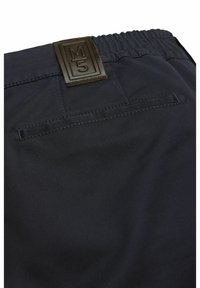 Un pantalon bleu marine avec une texture lisse, doté d'une taille élastique et d'une étiquette en cuir marron portant la mention "M5" au dos.