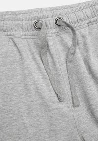 Grå sweatpants med ett elastiskt midjeband med dragsnören, mjuk textur och sidofickor. Inga synliga mönster eller hårdvarudetaljer.