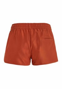 Bañadores cortos y de corte holgado en un color naranja óxido sólido, fabricados en un material ligero. Cuentan con una cinturilla elástica y un bolsillo trasero.