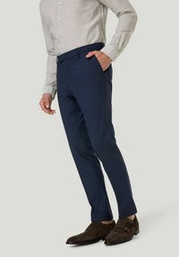 Marineblau maßgeschneiderte Hose mit glatter Textur, kombiniert mit einem hell gestreiften Langarmhemd und dunkelbraunen Wildleder-Doppelschnallen-Schuhen.