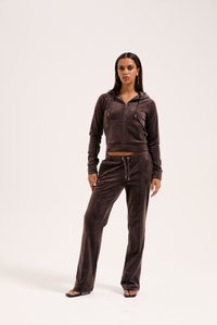 Brun velour træningsdragt med en cropped zip-up hættetrøje med frontlommer og matchende lange bukser med snoretræk i livet og sidelister.