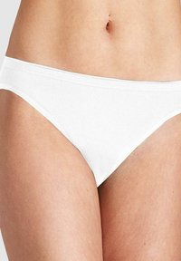 Nahaufnahme des Unterbauchs und der Oberschenkel einer Frau, die einfache weiße Baumwollunterwäsche im Bikinityp trägt.