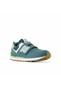 Zapatillas New Balance en color azul verdoso con acentos en verde y blanco, que cuentan con un upper texturizado, doble cinta de velcro y una suela de goma.