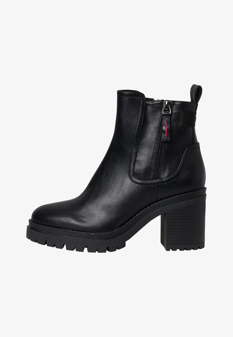 Bottine en cuir noir avec talon épais, fermeture éclair latérale, languette de tirage et semelle à crampons robustes, vue de côté extérieur.