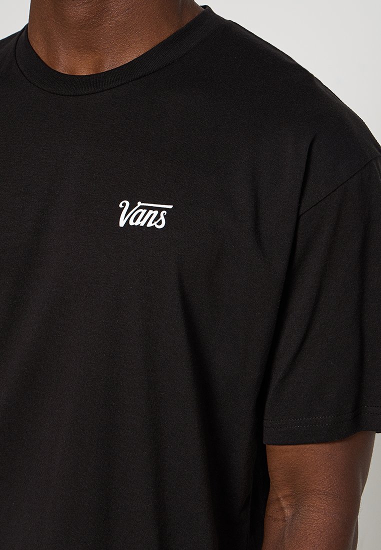 Camiseta de algodón negra con un logo blanco de "Vans" en la parte izquierda del pecho. Mangas cortas y un diseño clásico de cuello redondo.