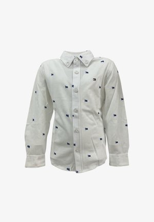 Camicia bianca a maniche lunghe con piccoli motivi a bandiera blu, chiusura frontale con bottoni e colletto a punta. Realizzata in tessuto di cotone con una texture liscia.