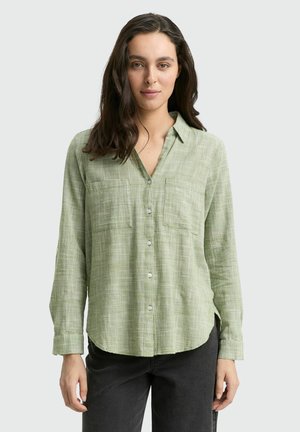 Camicia a maniche lunghe a scacchi verdi, con due taschini sul petto e una vestibilità comoda. Il tessuto ha un aspetto strutturato.