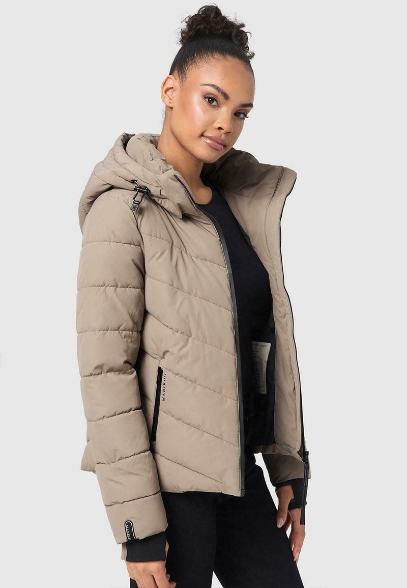 Pufferjack in lichtbeige met rits- en knoopsluiting, capuchon, diagonale stiksels en zijzakken. Geribbelde manchetten en logo-details.