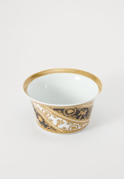 Tigela branca e preta com padrões dourados intrincados, uma borda larga e um acabamento liso e brilhante. Design elegante com um toque régio.