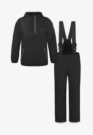 Schwarze wasserdichte Jacke mit Fronttasche und reflektierenden Reißverschlussakzenten, kombiniert mit schwarzen Latzhosen mit verstellbaren Trägern.