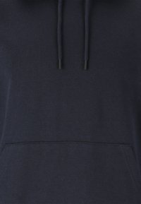 Marineblaue Kapuzenjacke mit einer Vordertasche, einer Kordelzugkapuze und einer weichen Textur. Schlichtes Design ohne sichtbare Muster oder Akzente.