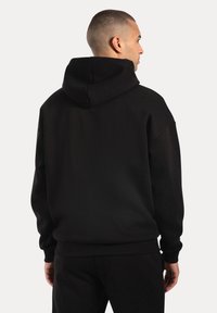 Czarna bluza z kapturem ze sznurkiem, z ściągaczami przy mankietach i u dołu, o miękkiej teksturze. Prosty design, bez widocznych logo ani wzorów.