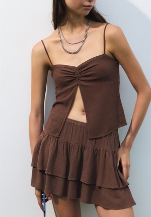 Top court en lin marron avec un fronçage à l'avant et une fente, associé à une jupe à volants superposés assortie, dotée d'une taille élastique.