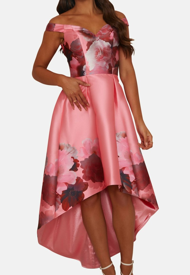 Růžové saténové šaty s odhalenými rameny, květinovou živůtkou a asymetrickým lemem. Skirt má červené a růžové květinové vzory.