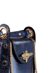 Marineblauwe leren handtas met een gestructureerde afwerking, een gouden kettingbandje en een decoratieve bij-sluiting op het klepvak. Metalen accenten zichtbaar.