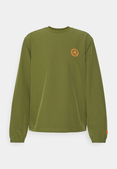 Olive green long-sleeve shirt in soft fabric, round neckline, fitted cuffs, and a circular orange logo on the left chest. Seamless design.