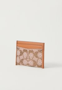 Cardholder din piele artificială bej și plasă texturată roz cu modele circulare, având sloturi pentru cărți și cusături contrastante.