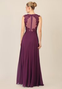 Lila bodenlanges Kleid mit transparentem Rücken und floralen Spitzenakzenten. Glatter Stoff, tailliertes Oberteil und verdeckter Reißverschluss.