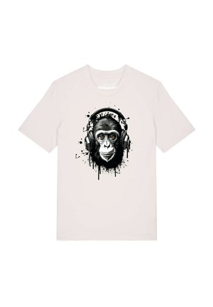 T-shirt blanc avec un visage de chimpanzé en noir et blanc portant un grand casque, entouré de taches de peinture abstraites.